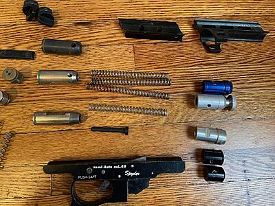 Strikers, and springs. There's a blue, a red, a green (that is missing most of the paint), and a silver, which I would assume to be stock. Also an assortment of back caps and velocity adjusters.