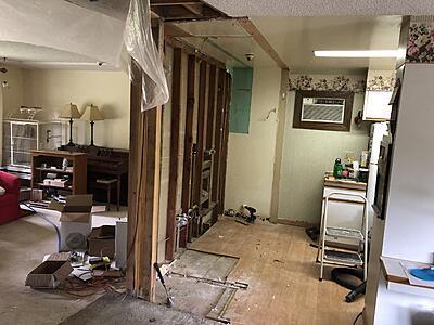 Demolishing the wall between the kitchen and living room. Beam is installed in the attic above the existing wall.